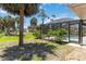 Landscaped backyard with palm trees and screen enclosed pool at 251 Broadmoor Ln, Rotonda West, FL 33947
