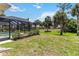 Landscaped backyard with palm trees and screen enclosed pool at 251 Broadmoor Ln, Rotonda West, FL 33947