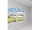 Bright bedroom featuring a large window overlooking a landscaped yard, neutral paint, and white carpet at 251 Broadmoor Ln, Rotonda West, FL 33947