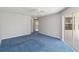 Bedroom featuring blue carpeting, ceiling fan, and a sliding glass door to the screened-in lanai at 251 Broadmoor Ln, Rotonda West, FL 33947