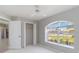 Bright bedroom featuring a ceiling fan, closet, and a large arched window with a pleasant view at 251 Broadmoor Ln, Rotonda West, FL 33947