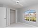A cozy bedroom featuring a ceiling fan, closet, and a bright window offering a lovely view at 251 Broadmoor Ln, Rotonda West, FL 33947