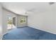 Bedroom with blue carpet, ceiling fan, a sliding glass door to the backyard and natural light at 251 Broadmoor Ln, Rotonda West, FL 33947