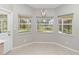 Bright breakfast nook with tile floor, three windows offering backyard views, and modern light fixture at 251 Broadmoor Ln, Rotonda West, FL 33947