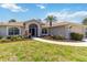 Well-maintained home featuring a screened entryway, manicured landscaping, and a paved walkway leading to the front door at 251 Broadmoor Ln, Rotonda West, FL 33947