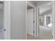 Neutral hallway showcasing doorway views into other rooms, doors, and carpeted floors at 251 Broadmoor Ln, Rotonda West, FL 33947