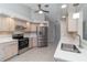 Kitchen with stainless appliances, light wood cabinets, tile floors and a view into the living area at 251 Broadmoor Ln, Rotonda West, FL 33947