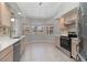 Spacious kitchen featuring stainless steel appliances, tile flooring, and ample natural light from windows at 251 Broadmoor Ln, Rotonda West, FL 33947