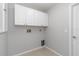 Practical laundry room with overhead cabinets, and tile flooring for convenient cleaning at 251 Broadmoor Ln, Rotonda West, FL 33947