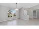 Open living space with neutral walls, tile floors, and a modern light fixture, with a view to the outside at 251 Broadmoor Ln, Rotonda West, FL 33947