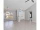 Bright, airy living space featuring neutral tile flooring, a modern chandelier, and a view of the landscaped yard at 251 Broadmoor Ln, Rotonda West, FL 33947
