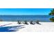 Relaxing beachfront seating area with white sand and water views at 276 Saint Lucia Dr # 101, Bradenton, FL 34209