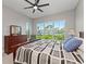Bedroom featuring a scenic view window, complemented by a dark wood dresser and a ceiling fan at 276 Saint Lucia Dr # 101, Bradenton, FL 34209