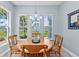 Sunny dining area featuring a round wood table and scenic waterfront views through multiple windows at 276 Saint Lucia Dr # 101, Bradenton, FL 34209