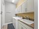 Well-lit laundry room features a modern washer and dryer and ample cabinet storage space at 276 Saint Lucia Dr # 101, Bradenton, FL 34209