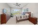 Comfortable bedroom featuring a coastal view from the large window and wooden furnishings, all illuminated by natural light at 276 Saint Lucia Dr # 101, Bradenton, FL 34209