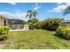 Spacious backyard featuring a screened pool area, lush landscaping, and a bright blue sky at 2801 Dalhart Ave, North Port, FL 34286