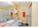 Bright bathroom with granite countertop, white cabinets, framed mirror, and enclosed shower at 2801 Dalhart Ave, North Port, FL 34286