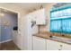 Kitchen with white appliances and plenty of natural light at 2801 Dalhart Ave, North Port, FL 34286