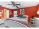 A colorful main bedroom featuring a queen bed, ceiling fan, en-suite bathroom, and closet at 2801 Dalhart Ave, North Port, FL 34286