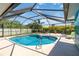 Private screened pool area with a sun lounger and a dining set on the patio at 2801 Dalhart Ave, North Port, FL 34286