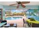 Covered lanai with furniture overlooking screened-in pool; backyard mural depicting tropical seascape at 2801 Dalhart Ave, North Port, FL 34286