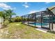 A refreshing screened-in pool is surrounded by lush landscaping, offering privacy and beauty at 2801 Dalhart Ave, North Port, FL 34286
