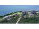 Stunning aerial view of the condo complex surrounded by lush landscaping, a golf course and a bay at 3070 Grand Bay Blvd # 644, Longboat Key, FL 34228