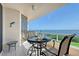 Relaxing condo balcony with beautiful gulf view, seating, dolphin wall hanging, and table set for dining at 3070 Grand Bay Blvd # 644, Longboat Key, FL 34228