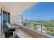 Balcony with glass railings overlooking tropical landscaping, nearby buildings, and bright blue skies at 3070 Grand Bay Blvd # 644, Longboat Key, FL 34228