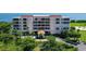 Exterior view of a multi-story residential building with a red tile roof and well-manicured landscaping at 3070 Grand Bay Blvd # 644, Longboat Key, FL 34228