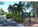 A sign to Longboat Key Club Harbourside is surrounded by tropical landscaping on a sunny day at 3070 Grand Bay Blvd # 644, Longboat Key, FL 34228