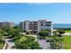 Beautiful exterior shot of this condo building, including entrance, parking lot, and meticulously maintained landscaping at 3070 Grand Bay Blvd # 644, Longboat Key, FL 34228