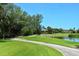 Picturesque view of the lush golf course with waterfront and luxury homes in the background at 3070 Grand Bay Blvd # 644, Longboat Key, FL 34228