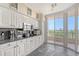 Bright kitchen features white cabinetry, granite countertops and stainless appliances with balcony access at 3070 Grand Bay Blvd # 644, Longboat Key, FL 34228