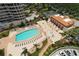 Aerial view of the community pool, tennis courts, and clubhouse surrounded by tropical landscaping at 3070 Grand Bay Blvd # 644, Longboat Key, FL 34228