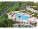 Aerial view of community pool with poolside seating, lush landscaping, and convenient parking at 3070 Grand Bay Blvd # 644, Longboat Key, FL 34228