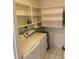 Laundry area features washer, dryer, water heater, and ample shelving for storage at 3231 Cambridge Dr, Sarasota, FL 34232