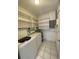 Laundry area features washer, dryer and ample shelving for storage at 3231 Cambridge Dr, Sarasota, FL 34232