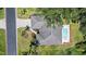 Aerial view of home with in-ground pool, lawn, and mature trees at 3335 Meadow Run Ter, Venice, FL 34293