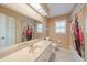 Bathroom with a neutral vanity, tiled floor, and a shower-tub combination behind a curtain at 3335 Meadow Run Ter, Venice, FL 34293