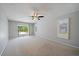 Bedroom with a ceiling fan, neutral walls, carpet, shuttered windows and sliding door access to the outside at 3335 Meadow Run Ter, Venice, FL 34293