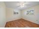 Bedroom with wood floor, ceiling fan, and windows with plantation shutters at 3335 Meadow Run Ter, Venice, FL 34293