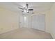 Bedroom featuring neutral carpet, ceiling fan with light, and a double door closet at 3335 Meadow Run Ter, Venice, FL 34293