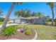 Charming single-story home with a well-manicured lawn, lush landscaping, and an attached two-car garage at 3335 Meadow Run Ter, Venice, FL 34293