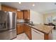 Stainless steel refrigerator and granite countertops accent the wood cabinets of this kitchen at 3335 Meadow Run Ter, Venice, FL 34293