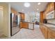 Well-lit kitchen boasts granite countertops, stainless steel appliances, wood cabinets, and tile flooring at 3335 Meadow Run Ter, Venice, FL 34293