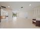 Open-concept living room with tile flooring, recessed lights, and access to the backyard through sliding glass doors at 3335 Meadow Run Ter, Venice, FL 34293