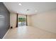 Bright and open living room features neutral tile, recessed lighting, and sliding doors with view of pool at 3335 Meadow Run Ter, Venice, FL 34293