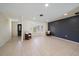 Spacious living room boasts neutral tile floors, recessed lighting, a bay window and dark accent wall at 3335 Meadow Run Ter, Venice, FL 34293